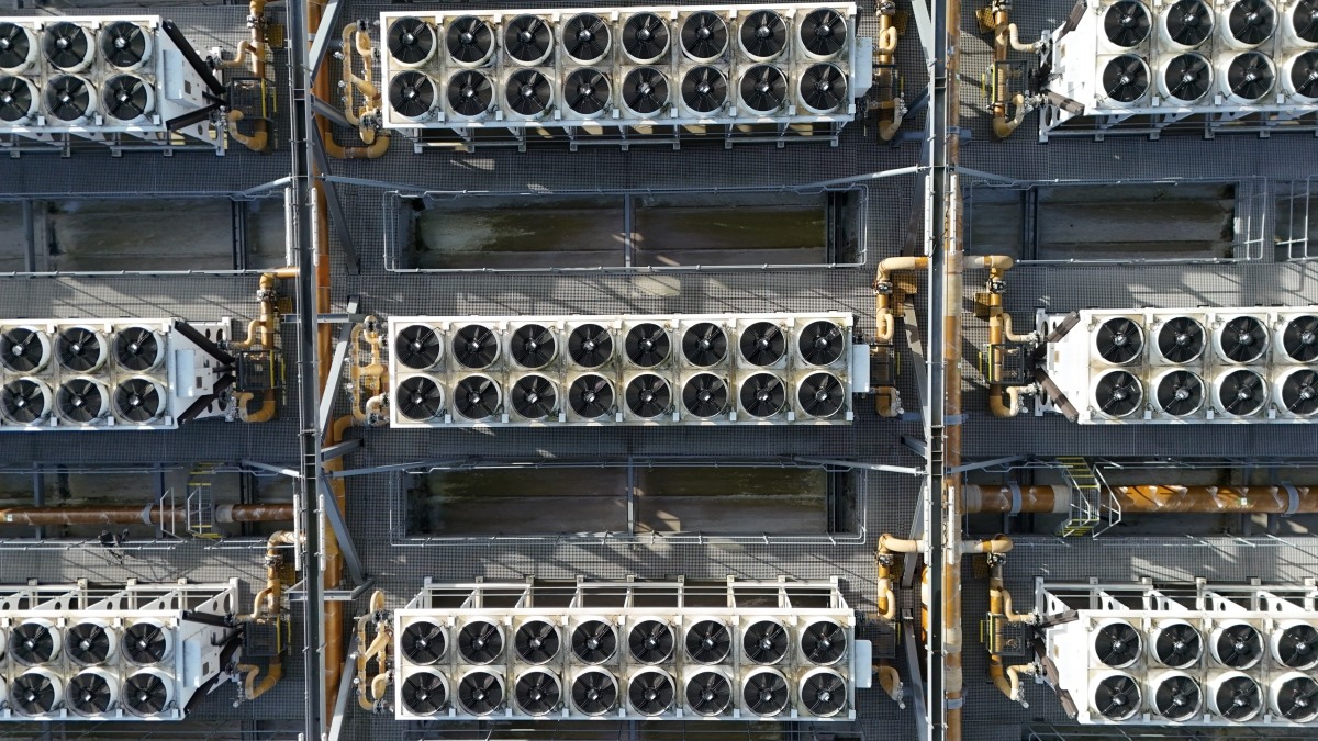 Vista dall’alto di grandi batterie di ventilatori e apparecchiature di raffreddamento su un datacenter.